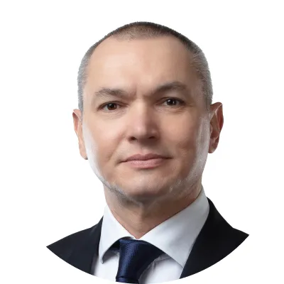 Portrait of a middle-aged man in a suit and tie with short gray hair against a white background.